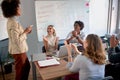 Presentation by young afro-american businesswoman to a team of businesspeople