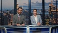 Presenters broadcasting breaking news late studio closeup. Smiling hosts talking