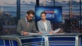 Presenters lighting breaking news in late tv studio closeup. Anchors discussing