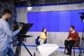 Presenters and video camera operator working. News broadcasting