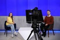 Presenters working in studio, focus on camera