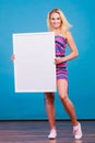Happy positive blonde woman holding blank white board Royalty Free Stock Photo