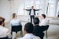 Male speaker giving presentation in hall at workshop. Audience or conference hall. Rear view of unrecognized Royalty Free Stock Photo