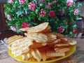 Presenting potato chips on a yellow plate with a flowers background. Royalty Free Stock Photo