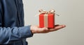 Presenting a Red Gift A Hand Holding a Beautifully Wrapped Present Ready to be Given Royalty Free Stock Photo