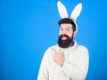 Presenting your product. Easter hare pointing finger aside. Bearded man in rabbit costume. Hipster wearing long rabbit