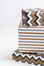 Presents Wrapped in striped and chevron geometric paper on white table close up