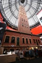 Preserving old historic brick Coop`s Shot Tower indoor under modern black steel truss glass dome inside Melbourne Central Mall