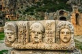 Preserved bas reliefs with floral ornaments and masks. Myra Ancient City rock tombs in background. Demre, Antalya, Turkey Royalty Free Stock Photo