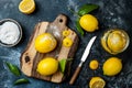 Preserved, salted canned lemons on a wooden board over black stone background. Moroccan cuisine.