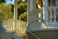 Presidential style plantation stairway on front of house or home with white balcony and steps on exterior or backyard in