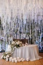 The presidium of the newlyweds in the banquet hall of the restaurant is decorated with candles and green plants