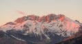 Presolana is a mountain range of the Orobie, Italian Alps. Landscape in winter. At sunset the rocks become red, orange and pink