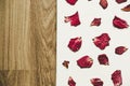 Press dried rose flower with petals, on white paper and wood floor, vintage tone