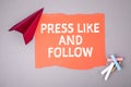 PRESS LIKE AND FOLLOW concept. Text on note sheet, paper plane, symbol of gaining goals