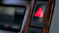 Pressed and glowing emergency car hazard warning flasher button on dashboard Royalty Free Stock Photo