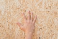 Pressed sawdust in the board. Hand on the board of compressed sawdust. background of pressed beige wooden sawdust. Royalty Free Stock Photo