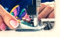 Presser foot of sewing machine with needle and thread close up. Detail of sewing machine with female fingers. Women`s hands sewin Royalty Free Stock Photo