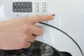 Presses the start button with his finger on  washing machine close-up Royalty Free Stock Photo