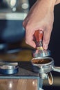 Pressing ground coffee tamper making espresso closeup. Royalty Free Stock Photo