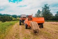 Pressing hay into bales, old working press, harvesting and harvesting dry fodder Royalty Free Stock Photo