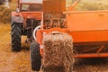 Pressing hay into bales, old working press, harvesting and harvesting dry fodder Royalty Free Stock Photo