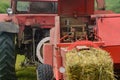 Pressing hay into bales, old working press, harvesting and harvesting dry fodder Royalty Free Stock Photo