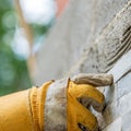 Pressing an ornamental tile into a glue on a wall