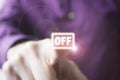 Pressing a virtual Off button a right hand of a Caucasian man in purple shirt Royalty Free Stock Photo