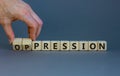 Pression to oppression symbol. Businessman turns wooden cubes, changes the word pression to oppression. Beautiful grey background