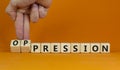 Pression to oppression symbol. Businessman turns wooden cubes, changes the word pression to oppression. Beautiful orange
