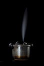 Pressure cooker releasing steam through the lid, on a black background