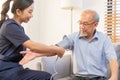 Pressure measurement of hypertension in elderly man sitting on couch, young woman nurse or caregiver care checking, measuring Royalty Free Stock Photo