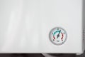 Pressure scale with an arrow on the wall of a white water heater close-up Royalty Free Stock Photo