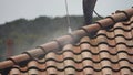 Pressure-washing a tile roof on a home Royalty Free Stock Photo