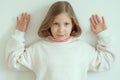 Preteen adorable girl with surrendering gesture standing on white background