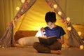 Preteen boy with flashlight reading book Royalty Free Stock Photo