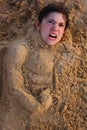 Preteen boy head in the beach sand happy smiling Royalty Free Stock Photo