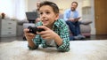 Preteen boy playing video game, dad and granddad smiling, leisure and hobby