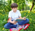 Preteen boy reading book outdoor spring Royalty Free Stock Photo