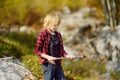 Preteen boy in red shirt is exploring nature and having fun during hiking in mountains valley on sunny day. Active leisure for Royalty Free Stock Photo