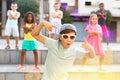 Preteen boy in sunglasses dancing krump with tweens on city street Royalty Free Stock Photo