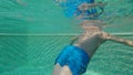 Preteen boy in the water while relaxing at swimming pool. Child body tempering.