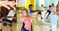 Preteen boys and girls practicing dance, stretching with female trainer in dance hall Royalty Free Stock Photo