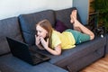 Preteen caucasian girl with amazed look chatting online using laptop for video call. Royalty Free Stock Photo