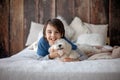 Preteen child, boy, playing with his pet, maltese dog at home Royalty Free Stock Photo