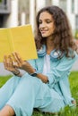 Preteen child girl relaxing interesting book turning pages smiling enjoying literature taking a rest Royalty Free Stock Photo