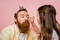 Preteen girl applying eyeshadow on father Royalty Free Stock Photo