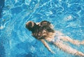 Preteen girl in bikini enjoys swimming in the pool. Childhood, vacation, travel concept