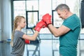 Preteen girl boxing with senior trainer